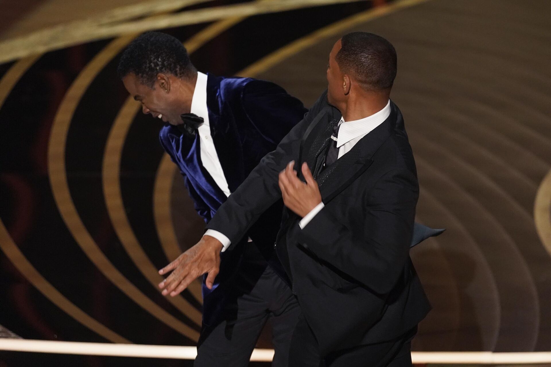 Will Smith, right, hits presenter Chris Rock on stage while presenting the award for best documentary feature at the Oscars on Sunday, March 27, 2022, at the Dolby Theatre in Los Angeles. - Sputnik International, 1920, 23.12.2022