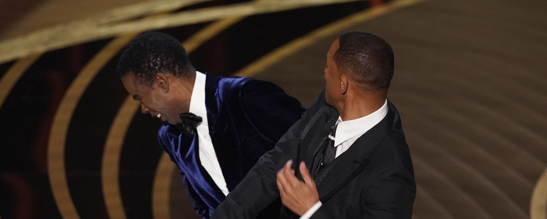 Will Smith, right, hits presenter Chris Rock on stage while presenting the award for best documentary feature at the Oscars on Sunday, March 27, 2022, at the Dolby Theatre in Los Angeles. - Sputnik International, 1920, 24.04.2022