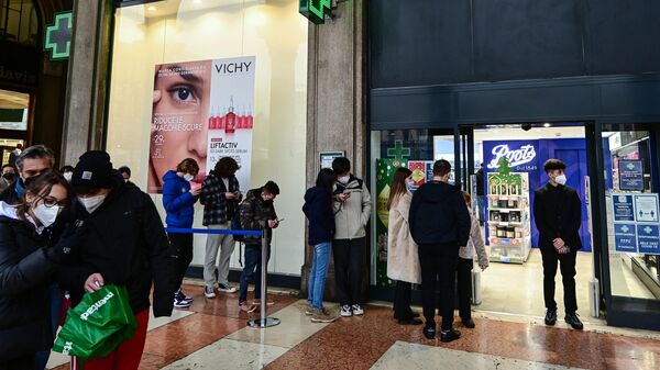 People line up outside a pharmacy to be tested for Covid-19, near the Duomo cathedral in the centre of Milan on January 4, 2022. - Sputnik International