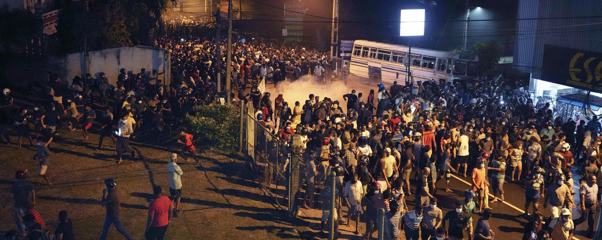 Protesters run to take cover as police uses tear gas shells to disperse them during a protest outside Sri Lankan president's private residence on the outskirts of Colombo, Sri Lanka, Thursday, March 31, 2022. - Sputnik International, 1920, 01.04.2022