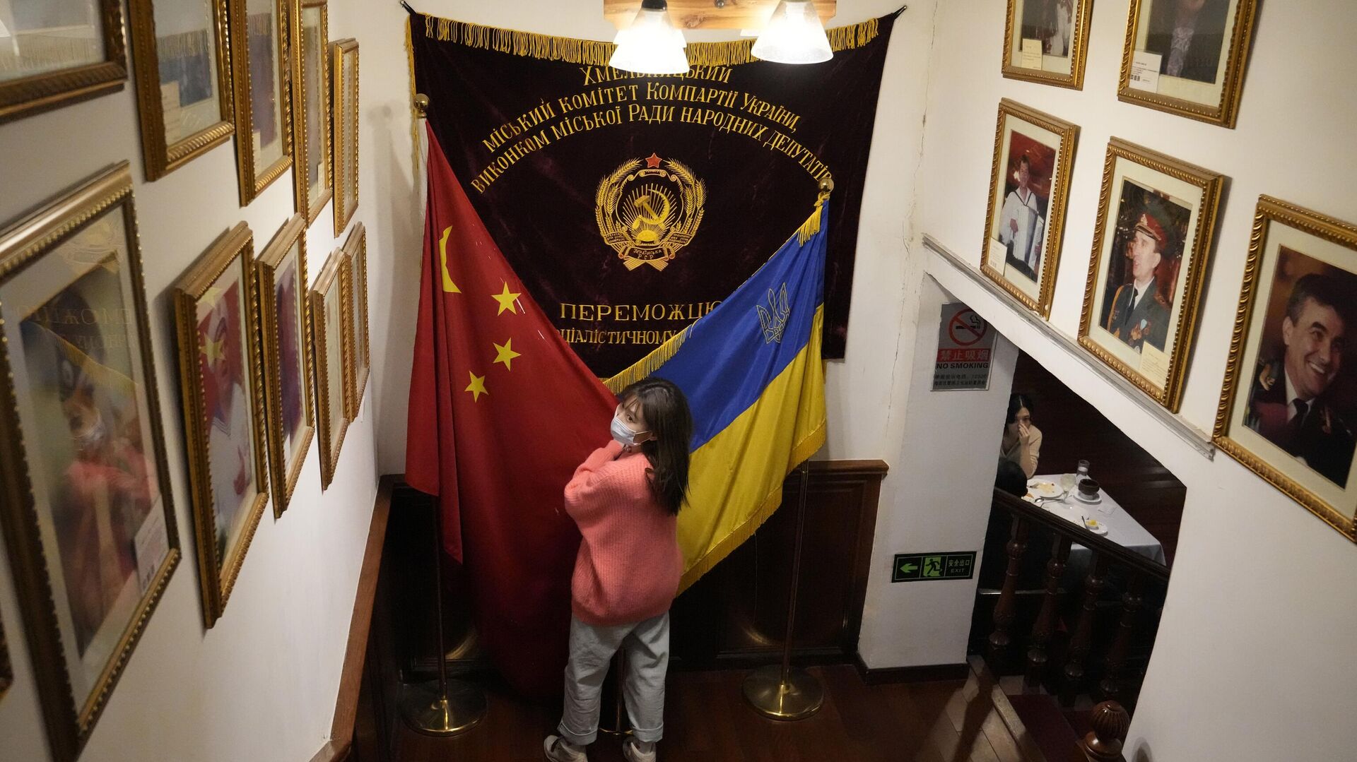 A visitor to a Ukraine restaurant holds together the Chinese and Ukraine national flags as she poses for a photo on Thursday, Feb. 24, 2022, in Beijing. - Sputnik International, 1920, 02.04.2022