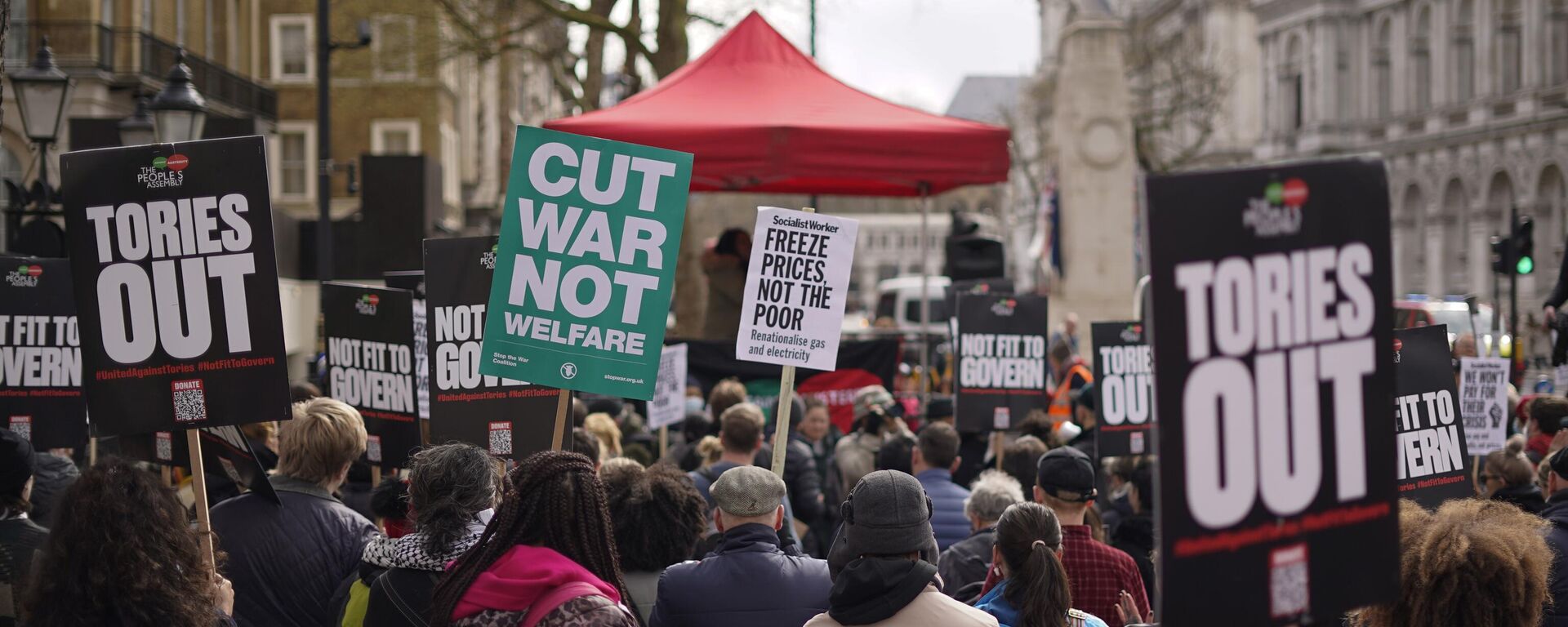 Demonstrators hold placards as they attend a protest, outside the gates of Downing Street, against the increase of the cost of living, in London, Saturday, April 2, 2022. - Sputnik International, 1920, 20.06.2022