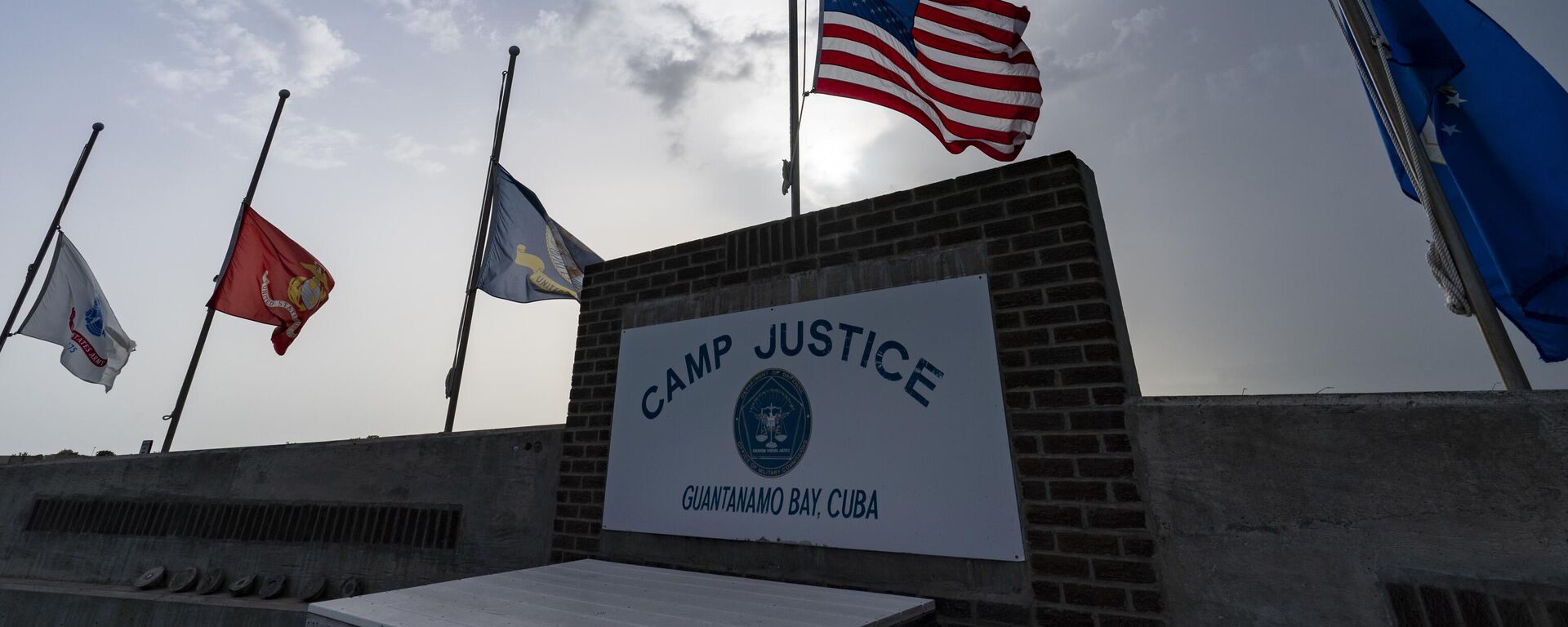 In this photo reviewed by U.S. military officials, flags fly at half-staff at Camp Justice, Aug. 29, 2021, in Guantanamo Bay Naval Base, Cuba. The Defense Department says Sufiyan Barhoumi, an Algerian man imprisoned at the Guantanamo Bay detention center for nearly 20 years, has been released and sent back to his homeland. - Sputnik International, 1920, 02.02.2023