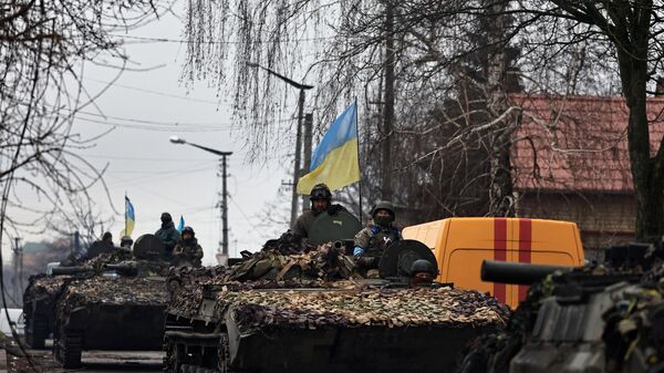 Ukrainian soldiers are pictured on their tanks as they drive along the street, amid Russia's invasion on Ukraine, in Bucha, in Kyiv region, Ukraine April 2, 2022. REUTERS/Zohra Bensemra - Sputnik International