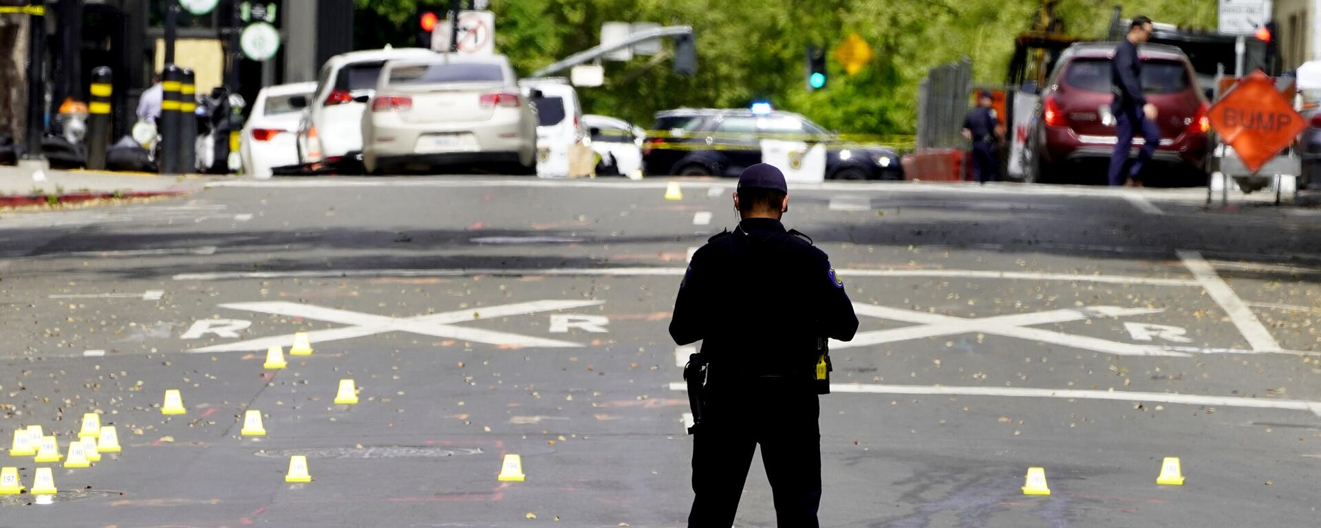 A Sacramento City Police Officer stands near a field of evidence markers after a mass shooting In Sacramento, Calif. April 3, 2022. - Sputnik International, 1920, 04.04.2022