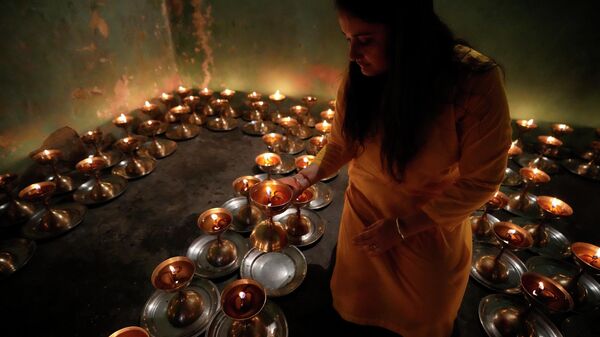 A Hindu devotee lights lamps inside the historical Baba Sidh Goria temple on the first day of the Navratri, or nine nights festival, in Jammu, India, Saturday, April 2, 2022.  - Sputnik International