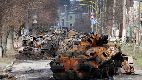 Ukrainian soldiers examine destroyed Russian military vehicles following a battle in Bucha, close to Kyiv, Ukraine, Monday, April 4, 2022. - Sputnik International