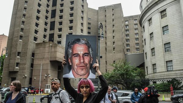 A member of a protest group called Hot Mess holds up a sign of Jeffrey Epstein in front of the Metropolitan Correction Center on July 8, 2019 in New York City. - Sputnik International