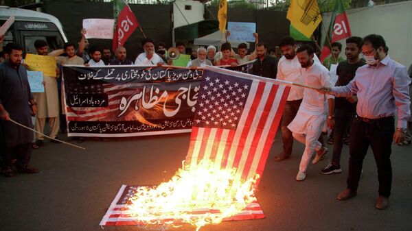 Pakistani Shiite Muslims and supporters of ruling party Pakistan Tehreek-e-Insaf burn a representation of U.S flag during an anti U.S protest, outside U.S consulate in Lahore, Pakistan, Friday, April 1, 2022. In an address to the nation on Thursday Pakistani Prime Minister Imran Khan lashed out at the United States, claiming Washington had conspired with the Pakistani opposition against him. - Sputnik International