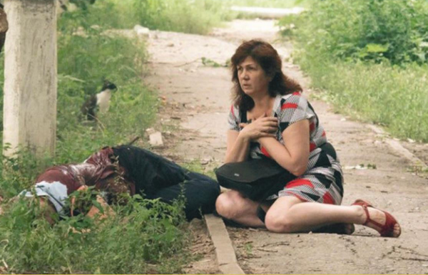 July 2014, Lugansk. A woman in a state of shock next to a victim of artillery shelling by the Ukrainian Armed Forces. - Sputnik International
