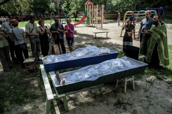 A funeral service for the dead in the courtyard of a residential building. The aftermath of artillery shelling by the Ukrainian Armed Forces of the Artem district in Slavyansk. - Sputnik International