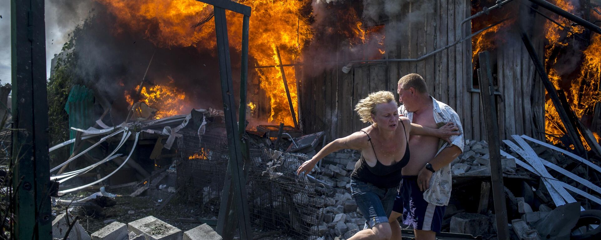Местные жители спасаются от пожара, возникшего в результате авиационного удара вооруженных сил Украины по станице Луганская - Sputnik International, 1920, 11.04.2022