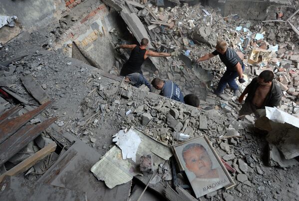 July 2014: Snezhnoe: Rescuers and local residents clear rubble in a home after a Ukrainian air raid. - Sputnik International