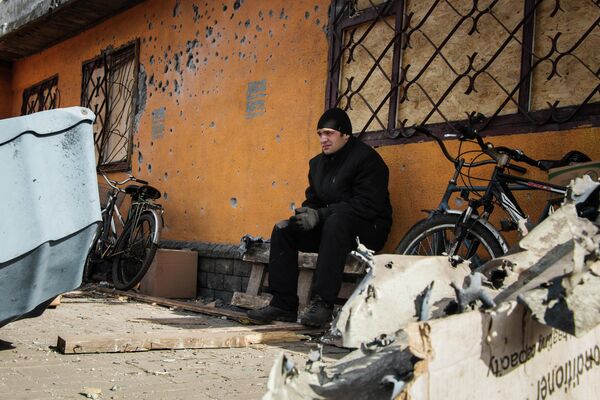 February 2015: A resident of the town of Debaltsevo, Donetsk People’s Republic sits near a building damaged by Ukrainian Army shelling. - Sputnik International