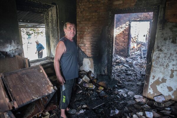 August 2015: Resident of the village of Alexandrovka, Donetsk People’s Republic stands in his wrecked home. The majority of the destruction of civilian infrastructure in the Donbass occurred between 2014 and 2015 in shelling and Ukrainian air attacks. - Sputnik International