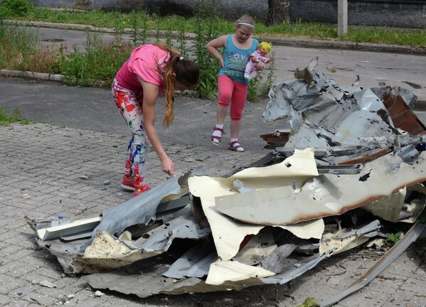 June 2017: Children inspect the cladding of a building damaged during shelling of the Kievsky district of the city of Donetsk. - Sputnik International