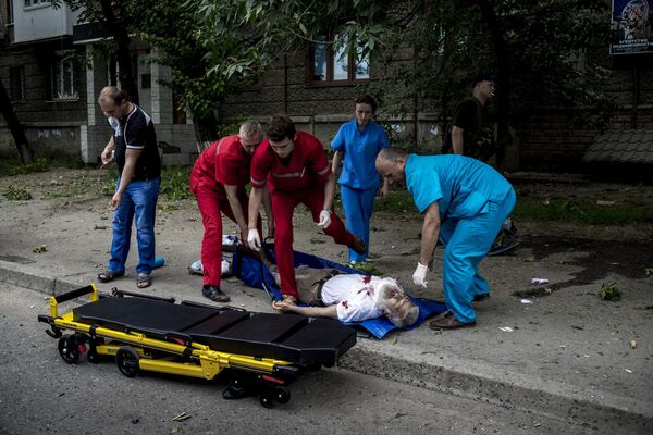 Unfortunately, not all of the wounded civilians could be delivered to the operating table in time.Above: Ambulance workers load a resident of Lugansk who was wounded during shelling onto a stretcher. - Sputnik International