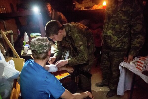 Medical workers provided medical aid to the Donbass militias which formed to repel Ukrainian forces’ advance. Some became militia members themselves.Above: A Donbass militiaman aids a wounded man following a tank attack on the village of Semyonovka, DPR. - Sputnik International