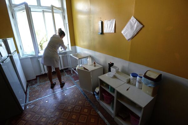 Nurse from the Gorlovka City Hospital cleans up pieces of broken glass after a Ukrainian artillery strike. - Sputnik International