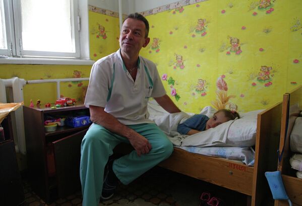 Doctor sits near a child undergoing treatment at the ‘Family and Health’ medical association clinic in Gorlovka, DPR. - Sputnik International