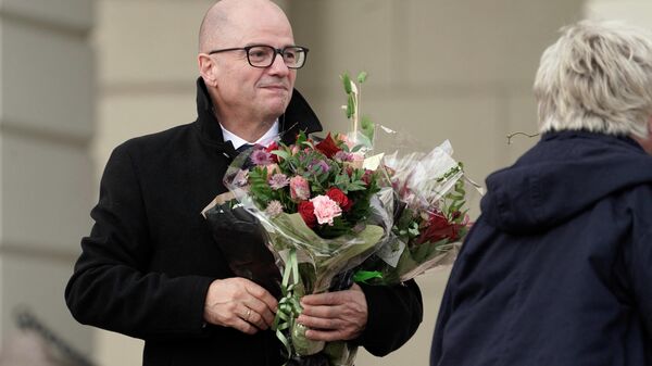 In this file photo taken on October 14, 2021 Norway's Minister of Defense Odd Roger Enoksen (Centre Party) holds a bouquet of flowers as he poses on Slottsplassen palace square in front of the Royal Palace in Oslo, after he became member of the new government. - Sputnik International