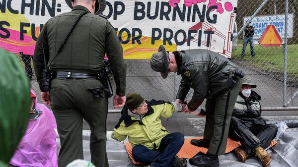People chained together are separated by officials during a protest against U.S. Senator Joe Manchin (D-WV), in Grant Town, West Virginia, U.S., April 9, 2022. - Sputnik International