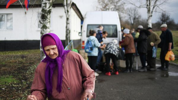 Local residents are seen in a street during receiving humanitarian aid in the village of Trokhizbenka that came under control of the Lugansk People's Republic.  - Sputnik International