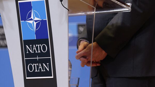 The hands of U.S. Secretary of State Antony Blinken are seen as he speaks to the media after a NATO foreign ministers meeting, amid Russia's invasion of Ukraine, next to the logo of NATO at its headquarters in Brussels, Belgium April 7, 2022 - Sputnik International