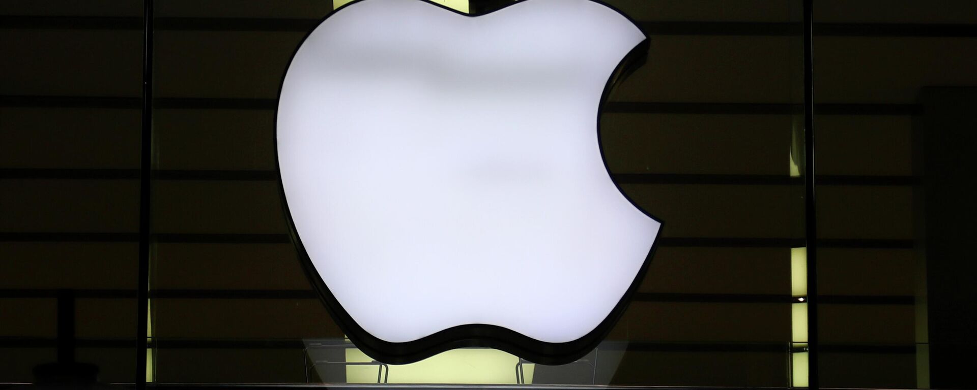 In this Wednesday, Dec. 16, 2020 file photo, the logo of Apple is illuminated at a store in the city center in Munich, Germany. Apple said late Wednesday Sept. 1, 2021, it is relaxing rules to allow some app developers such as Spotify, Netflix and digital publishers to include an outside link so users can sign up for paid subscription accounts.  - Sputnik International, 1920, 28.09.2022