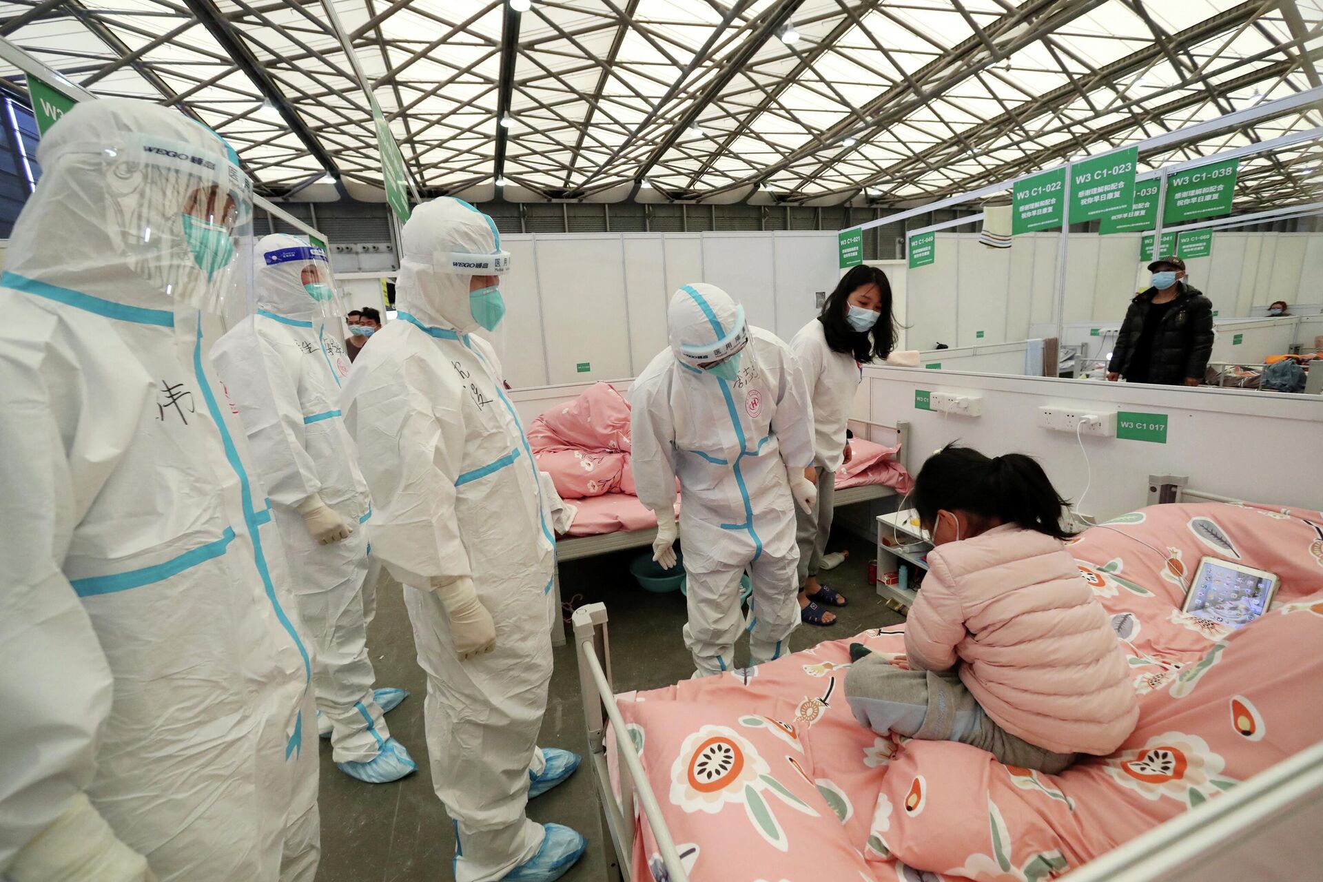 Medical workers in protective suits check a child patient as they conduct ward rounds at Shanghai New International Exhibition Hall, which has been turned into a makeshift hospital for the coronavirus disease (COVID-19), in Shanghai, China April 9, 2022. Picture taken April 9, 2022. China Daily via REUTERS   ATTENTION EDITORS - THIS IMAGE WAS PROVIDED BY A THIRD PARTY. CHINA OUT. - Sputnik International, 1920, 12.04.2022