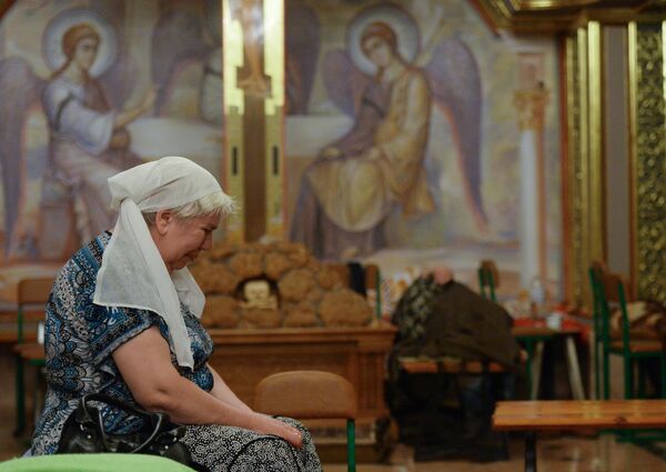 People were hiding from shelling not only in basements, but also in churches. Photo: A Gorlovka resident hiding from Ukrainian Army shelling in the Church of the Epiphany. - Sputnik International