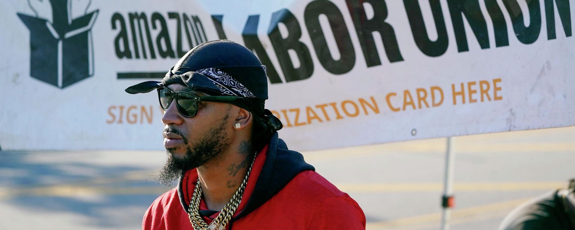 Christian Smalls, president of the Amazon Labor Union (ALU), stands by an information booth collecting signatures across the street from an Amazon distribution center in the Staten Island borough of New York, Thursday, Oct. 21, 2021. - Sputnik International, 1920, 12.04.2022