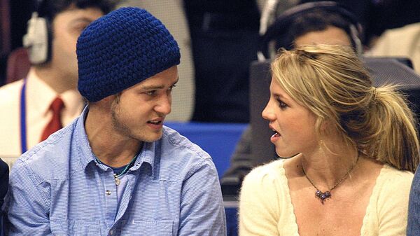 Pop superstars Britney Spears (R) and boyfriend Justin Timberlake (L) talk as they sit courtside at the NBA All-Star Game 10 February 2002 in Philadelphia - Sputnik International