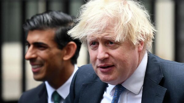 In this file photo taken on December 01, 2021 Britain's Prime Minister Boris Johnson (R) stands with Britain's Chancellor of the Exchequer Rishi Sunak during a meeting with Small Business Saturday entrepreneurs in Downing Street in central London - Sputnik International