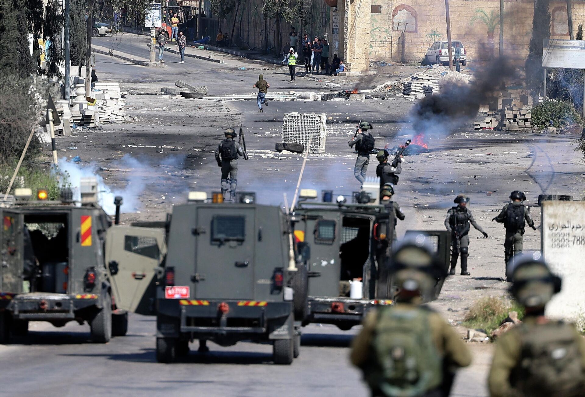Israeli security forces fire tear gas during clashes with Palestinian protesters following a demonstration against Jewish settlements and in support of Jerusalem's Al-Aqsa mosque, on the main street of Beita village in the occupied West Bank, on April 15, 2022.  - Sputnik International, 1920, 19.04.2022