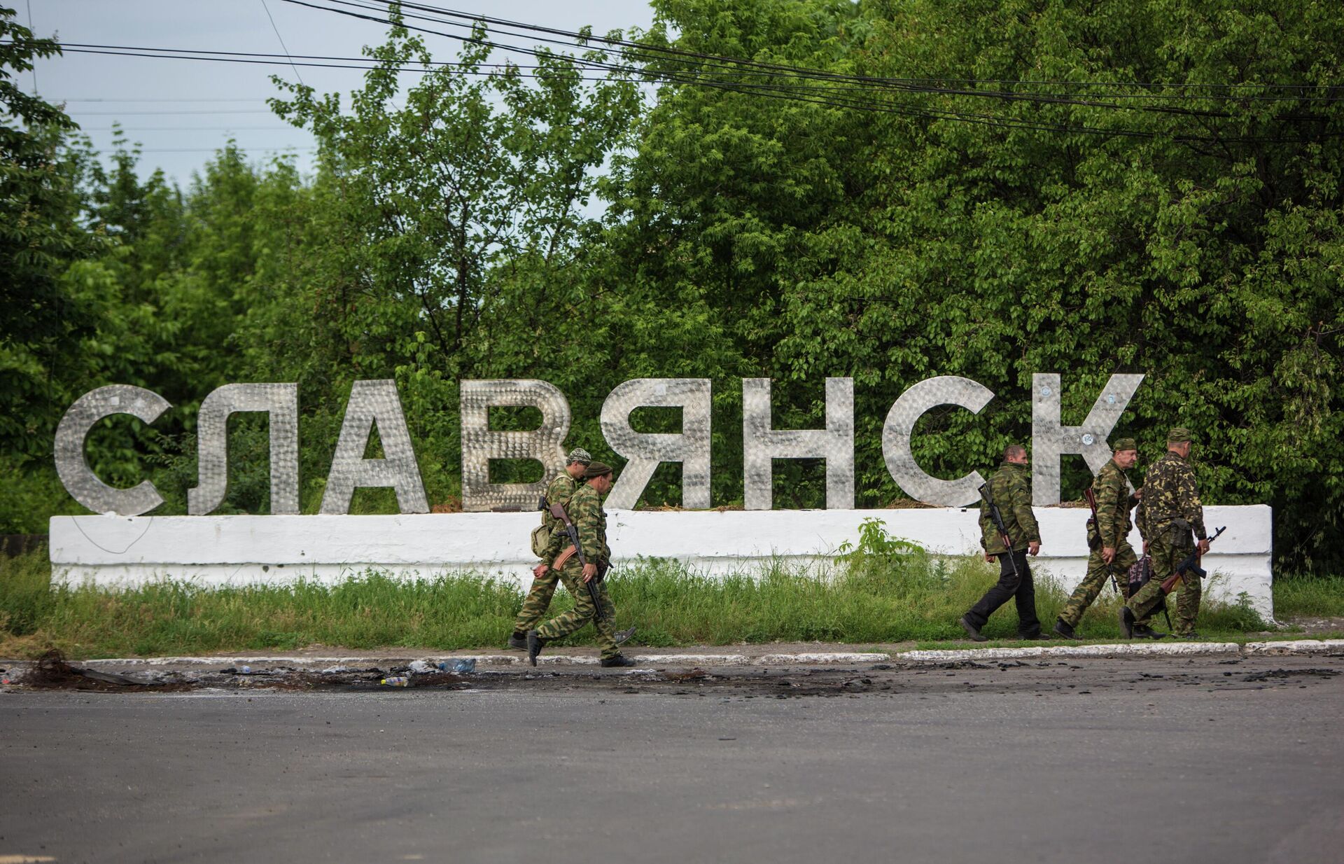 Donbass militiamen walk past a sign reading 'Slavyansk' along a road at the entrance to the city. - Sputnik International, 1920, 16.04.2022