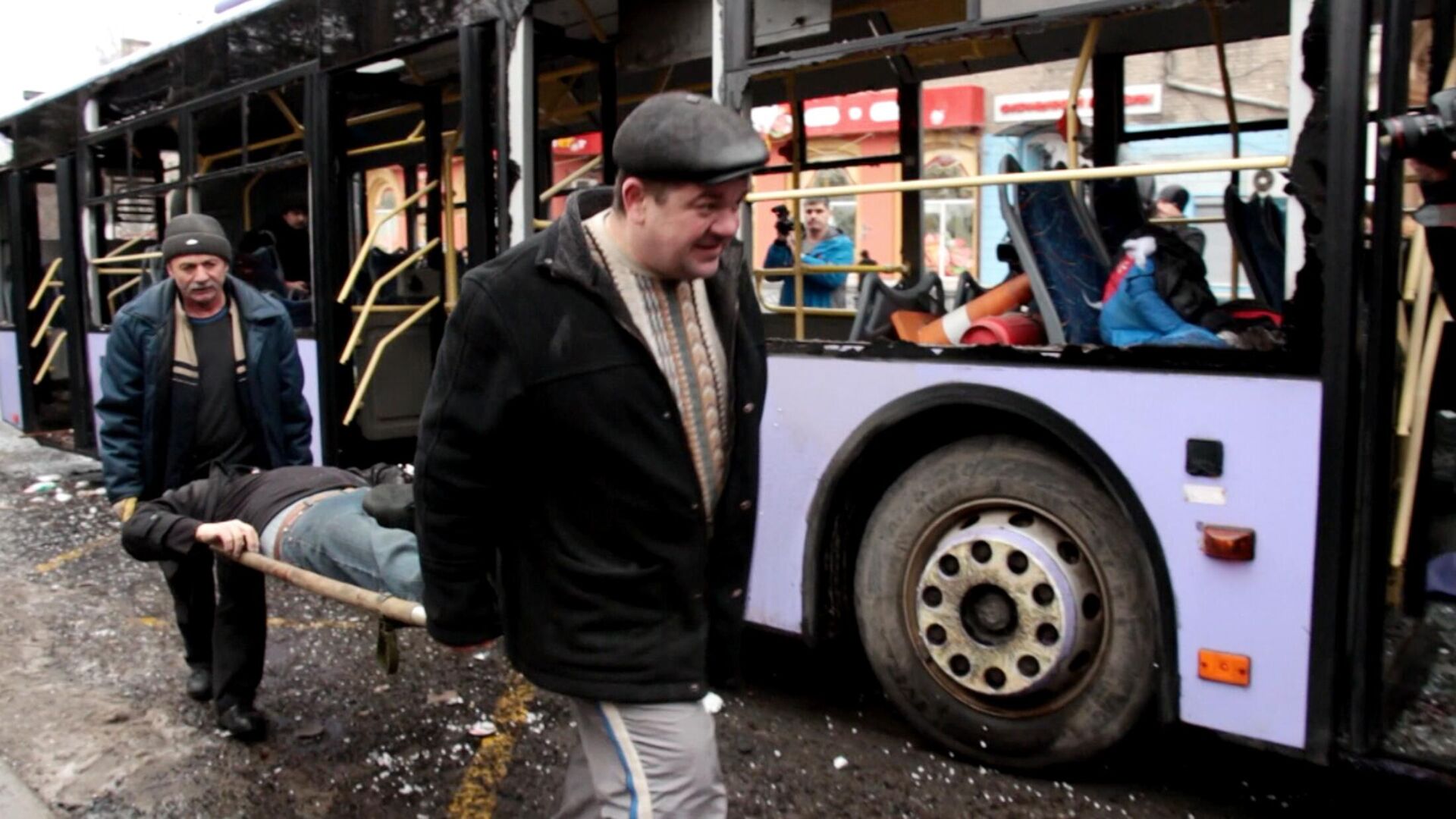 Residents of Donetsk take a victim out of a bus in wake of Ukrainian shelling of a bus stop in the city's Leninsky district. January 2015. Screengrab of Ruptly video. - Sputnik International, 1920, 16.04.2022