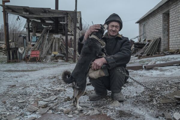 62-year-old Donbass resident Alexander Vasilyev with his pet pooch. Vasilyev is one of the last residents remaining in the village of Novomaryevka, DPR, which also found itself on the line of contact. This photo is from Valery Melnikov’s Grey Zone series, which won the grand prize at Italy’s Intarget Photolux Award photo contest in 2019. - Sputnik International