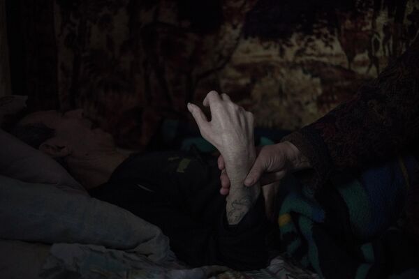 In this photo, 70-year-old Alexandra Chubarova holds the hand of her paralysed husband, 77-year-old Pyotr Chubarov. Alexandra and Petr are residents Novomaryevka. This photo is also from Valery Melnikov’s Grey Zone series. People who for one reason or another were unable to evacuate have also had to live with the threat of constant shelling. The paralysed, the bedridden, people who have suffered strokes, and those who cannot provide for themselves and live without outside help. - Sputnik International