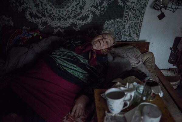 A woman in her home in the village of Sakhanka, DPR. Over half of the village’s pre-war population of about 1,000 left after the conflict began. Bedridden lonely elderly people could only hope for help from neighbours, but due to the shelling, such help has not always arrived in time. - Sputnik International