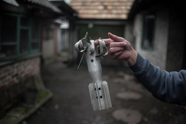 A woman shows a fragment of a mortar projectile in the village of Zaytsevo, Donetsk People’s Republic. Last month, the DPR’s Ministry of Emergency Situations declared that demining Donbass would take decades. - Sputnik International