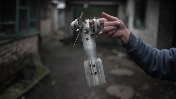 A woman shows a fragment of a mortar projectile in the village of Zaytsevo, Donetsk People’s Republic. Last month, the DPR’s Ministry of Emergency Situations declared that demining Donbass would take decades. - Sputnik International