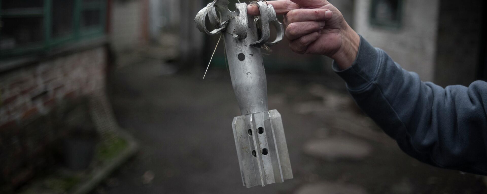A woman shows a fragment of a mortar projectile in the village of Zaytsevo, Donetsk People’s Republic. Last month, the DPR’s Ministry of Emergency Situations declared that demining Donbass would take decades. - Sputnik International, 1920, 12.05.2023