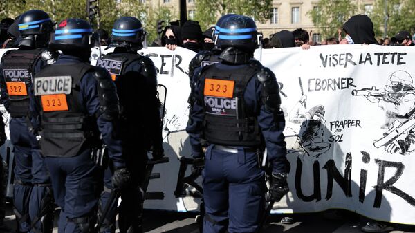 Protesters hold a banner depicting anti-riot police during a demonstration against 'racism and fascism' in Paris on 16 April, 2022. - Sputnik International