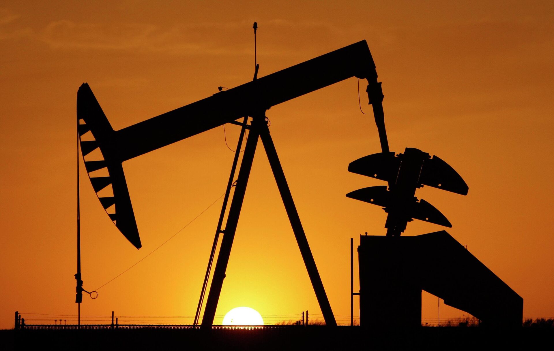 A pump jack is silhouetted against the setting sun in Oklahoma City on March 22, 2012. - Sputnik International, 1920, 05.10.2022