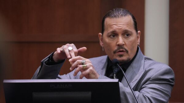 Actor Johnny Depp displays the middle finger of his hand, injured while he and his ex-wife Amber Heard were in Australia in 2015, as he testifies during his defamation trial against Heard at the Fairfax County Circuit Courthouse in Fairfax, Virginia, April 20, 2022 - Sputnik International