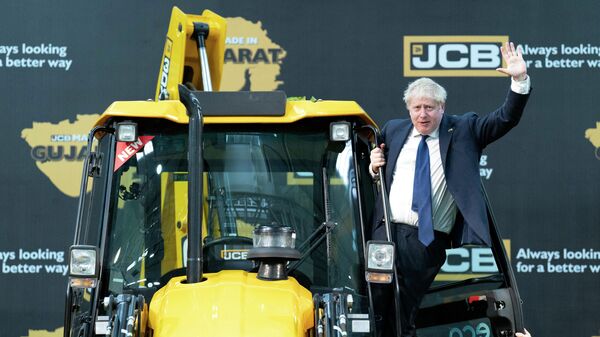 Britain's Prime Minister Boris Johnson waves from an excavator during his visit at the JCB factory in Vadodara on April 21, 2022.  - Sputnik International