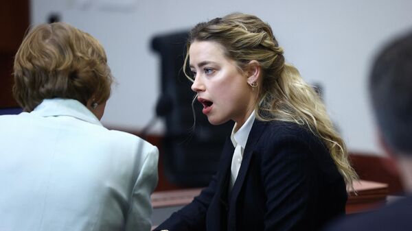 Actress Amber Heard speaks to her attorney during the defamation trial against her at the Fairfax County Circuit Courthouse in Fairfax, Virginia, April 21, 2022 - Sputnik International