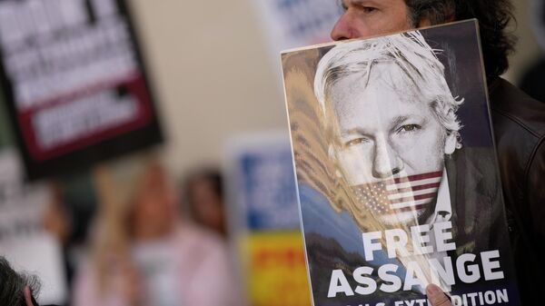 Wikileaks founder Julian Assange supporters hold placards as they gather outside Westminster Magistrates court In London, Wednesday, April 20, 2022. - Sputnik International