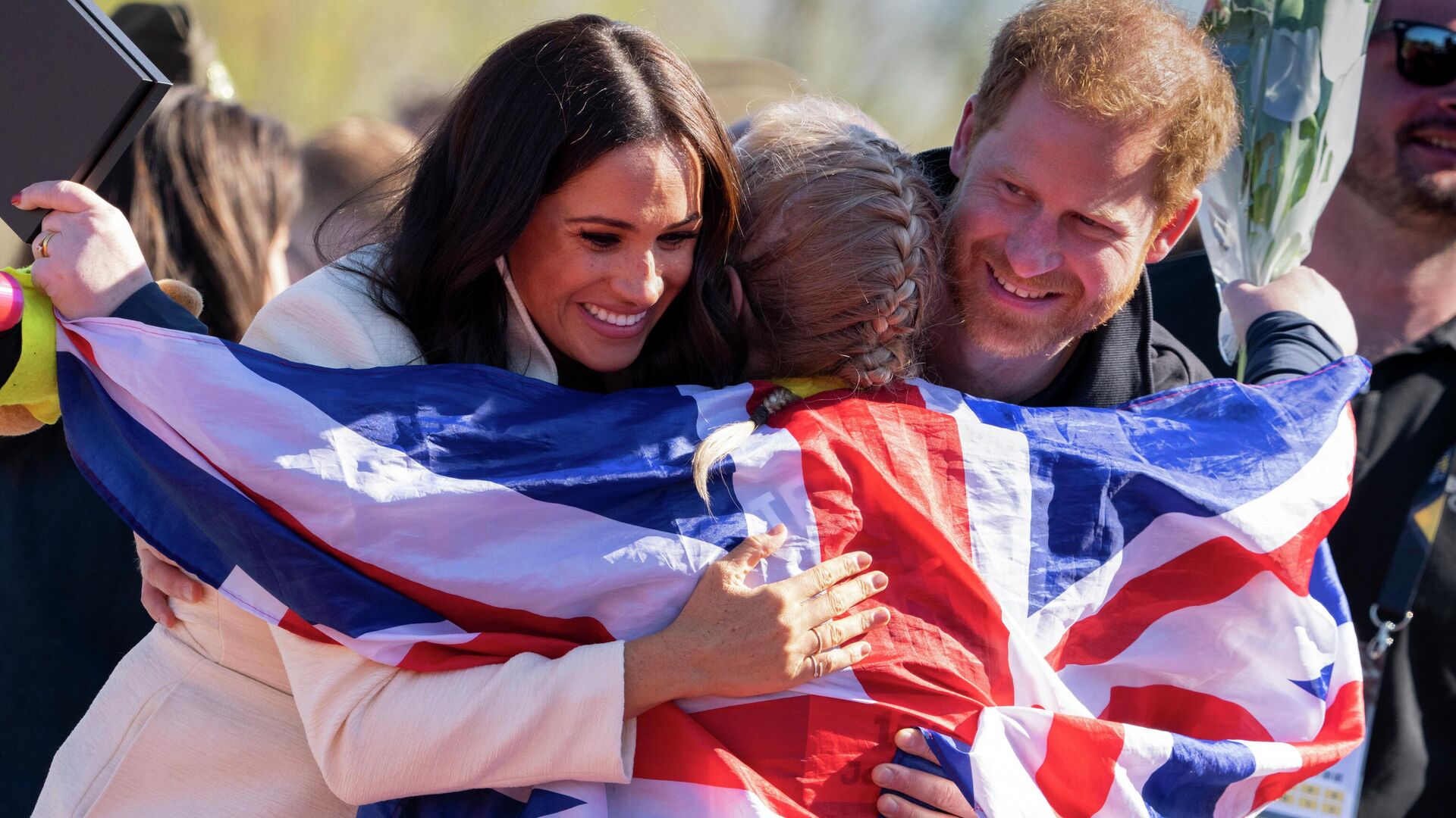 Prince Harry and Meghan Markle, Duke and Duchess of Sussex, hug Lisa Johnston, a former army medic and amputee, who celebrates with her medal at the Invictus Games venue in The Hague, Netherlands, Sunday, April 17, 2022 - Sputnik International, 1920, 22.04.2022